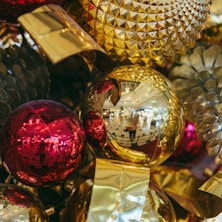 a pile of shiny christmas ornaments sitting on top of a table