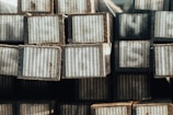 Wooden railway sleepers stacked neatly in a sunlit warehouse.
