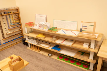 A calm, prepared learning environment with authentic Montessori materials neatly arranged.
