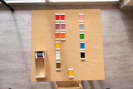 Hands arranging different terraforma tile samples on a wooden table.