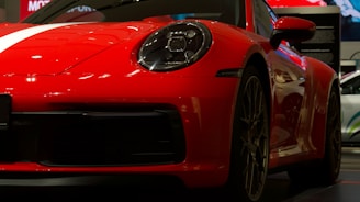 Side view of a red sports car gleaming on a driveway after a detailed polish