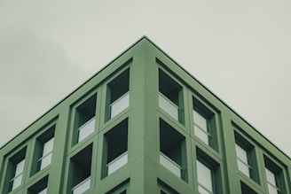 Minimalist line art of a modern office building with a subtle green accent.