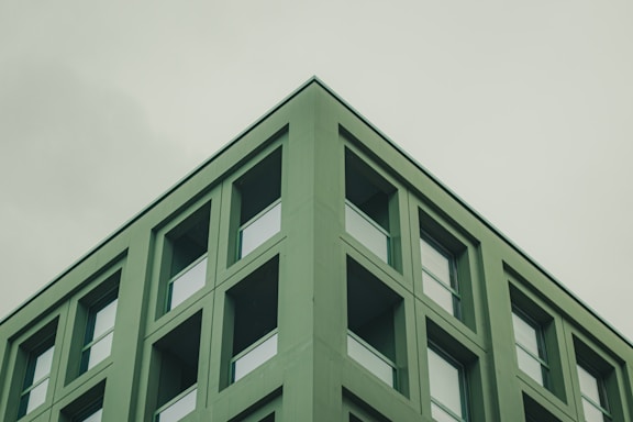 Minimalist line art of a modern office building with a subtle green accent.