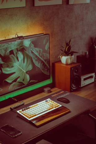 A bright, colorful workspace with tropical plants and a laptop displaying social media dashboards.