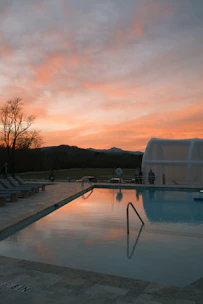 Swimming pool beside the villa reflecting the colorful sky.