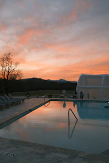Swimming pool beside the villa reflecting the colorful sky.