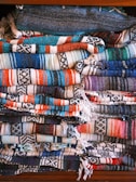 Finished woven blankets stacked neatly showing vibrant colors and designs
