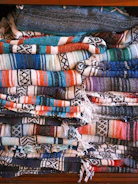 A neatly folded stack of colorful blankets displayed in a stylish retail store setting.
