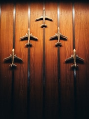 a group of four metal airplanes mounted to a wooden wall