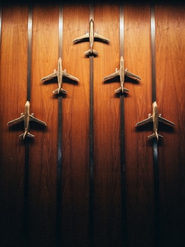 a group of four metal airplanes mounted to a wooden wall