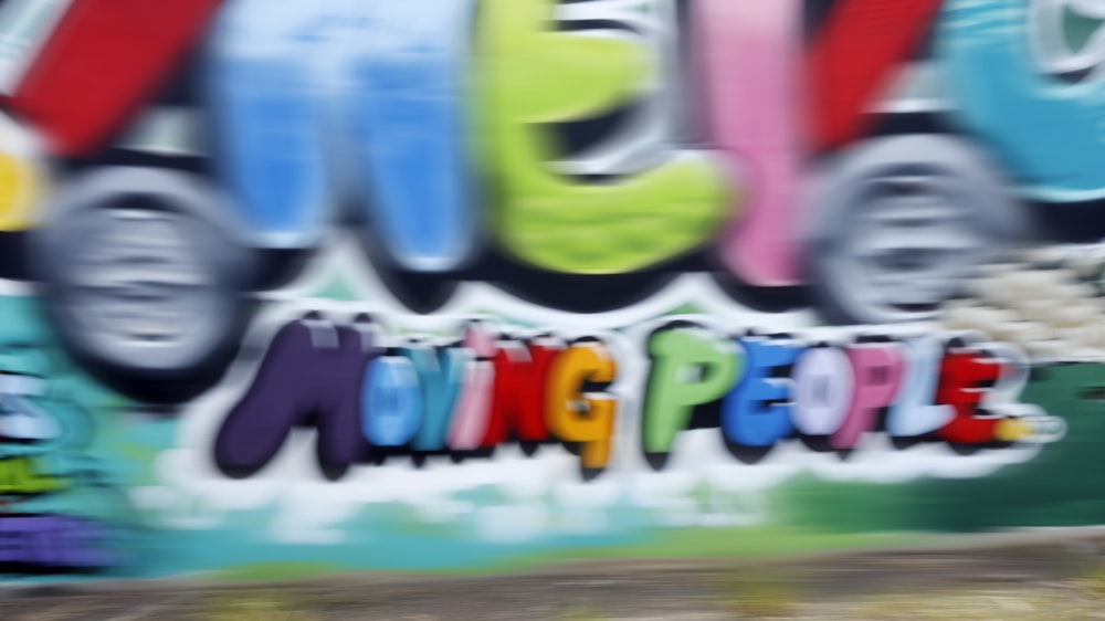 a man riding a skateboard past a graffiti covered wall