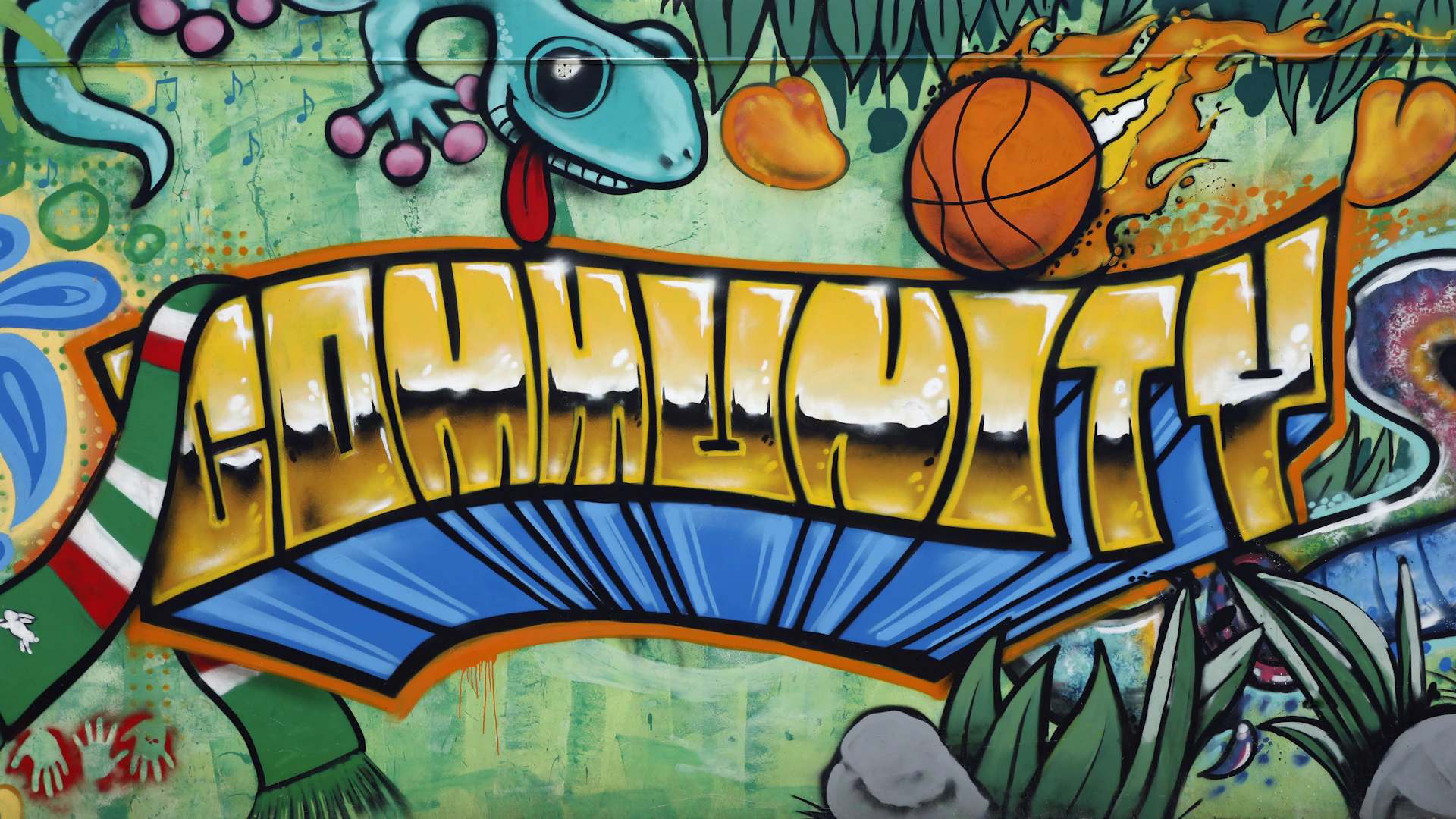 a graffiti wall with a dragon and a basketball on it