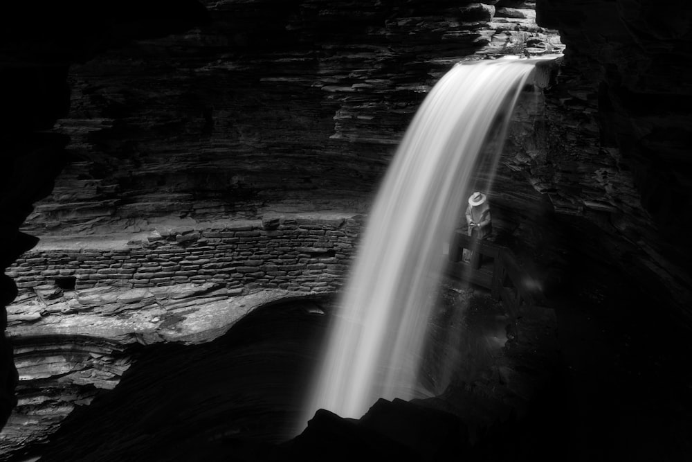 a person standing at the base of a waterfall