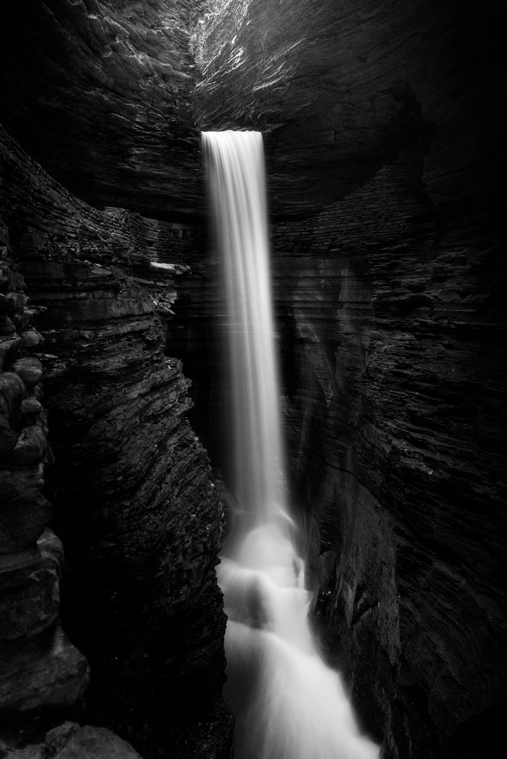 a black and white photo of a waterfall