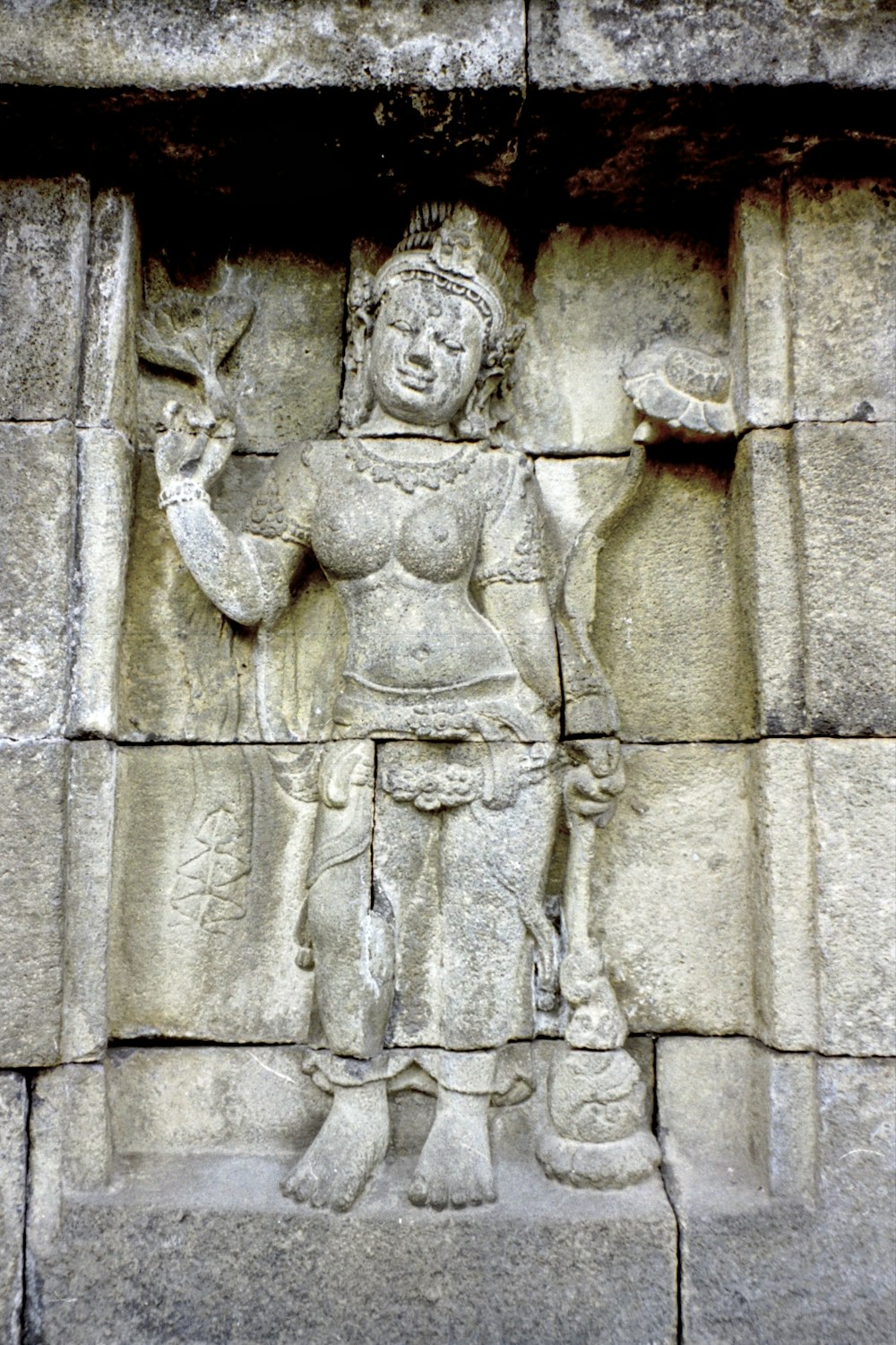 a stone carving of a woman holding a bird
