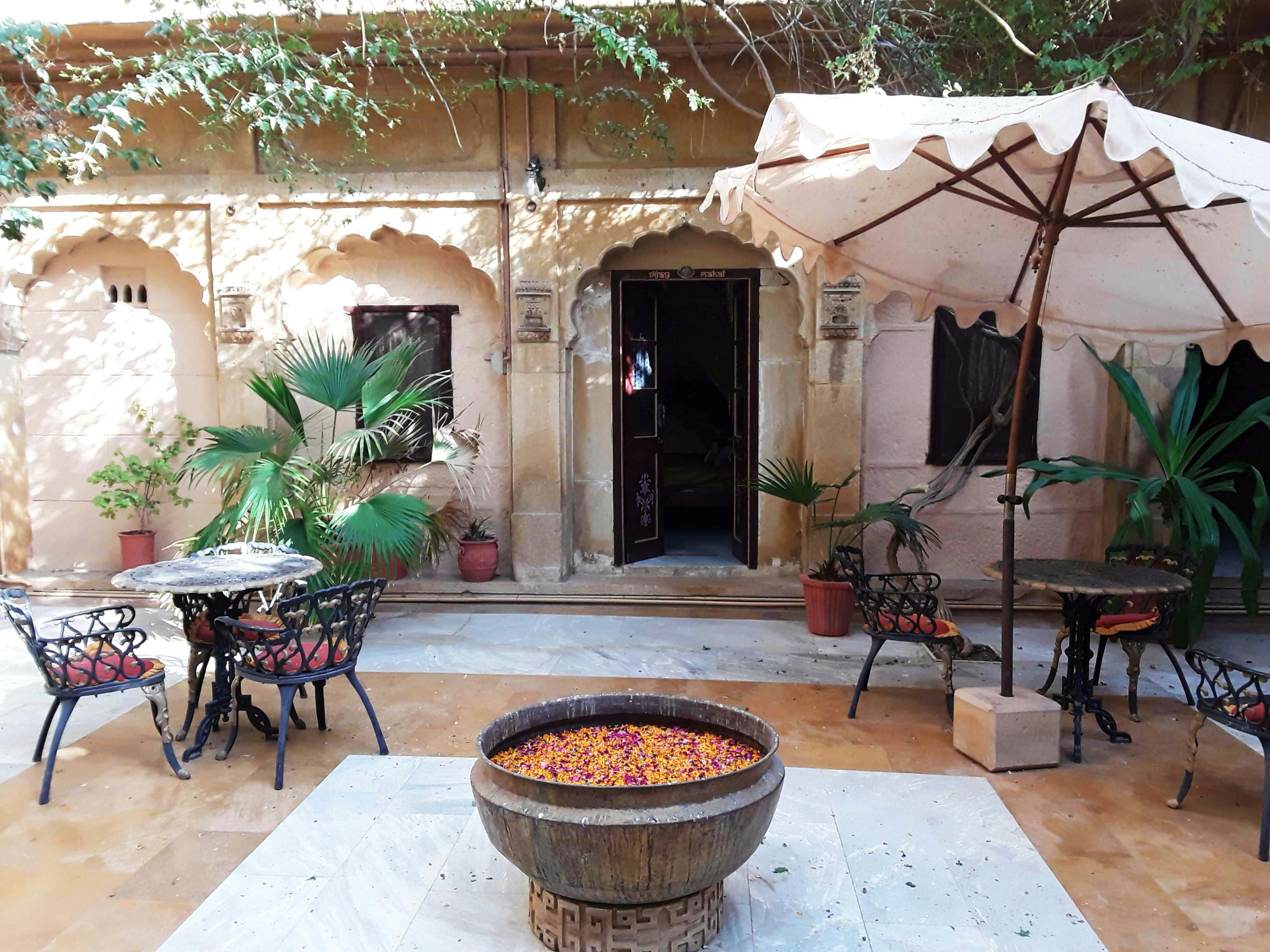 a patio with tables and chairs and an umbrella