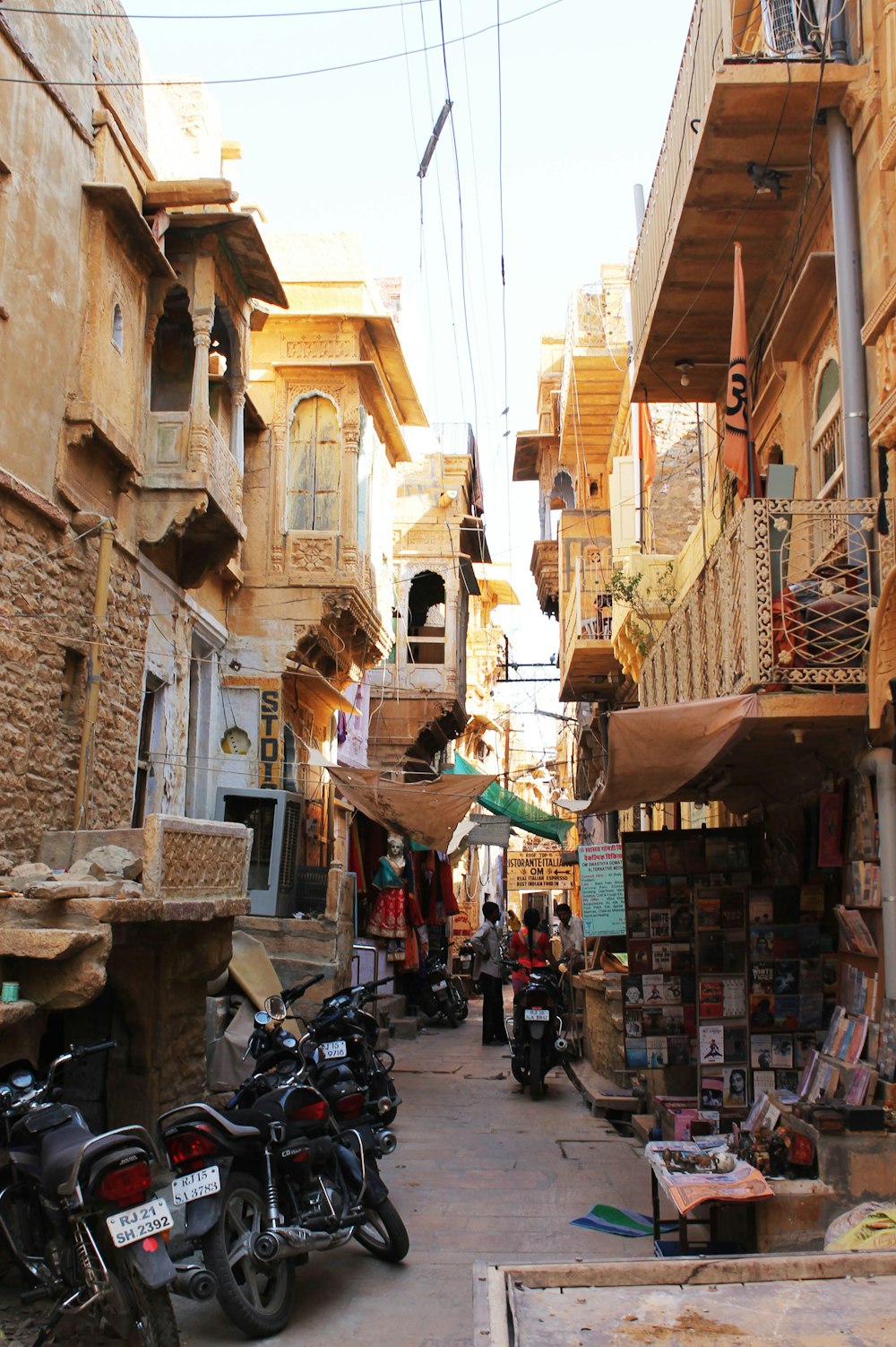 a narrow city street with lots of shops