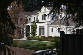 a large white house with a garden in front of it