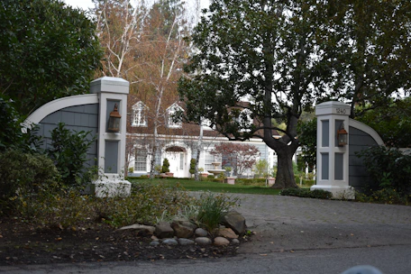 A beautifully installed brick and marble driveway bordered by lush landscaping.