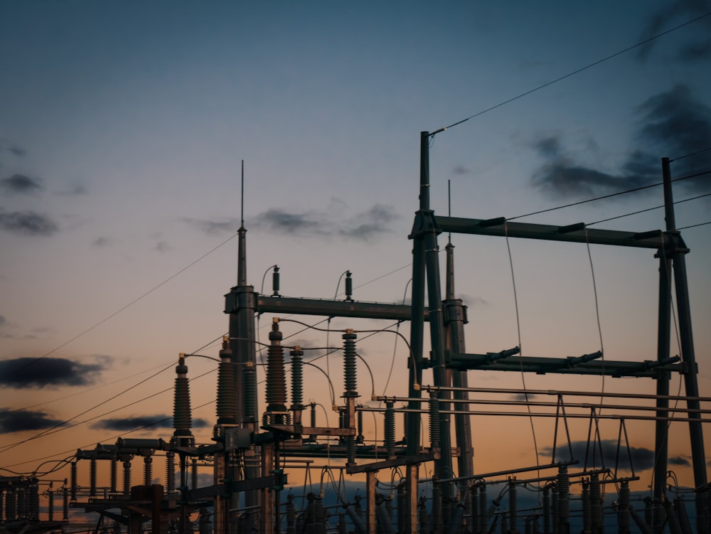 a group of power lines with a sky in the background