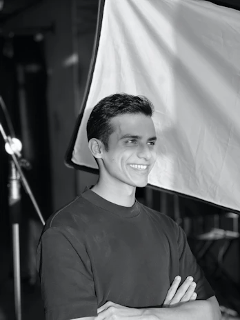A happy customer posing in front of a colorful backdrop inside Ikaura Studios.