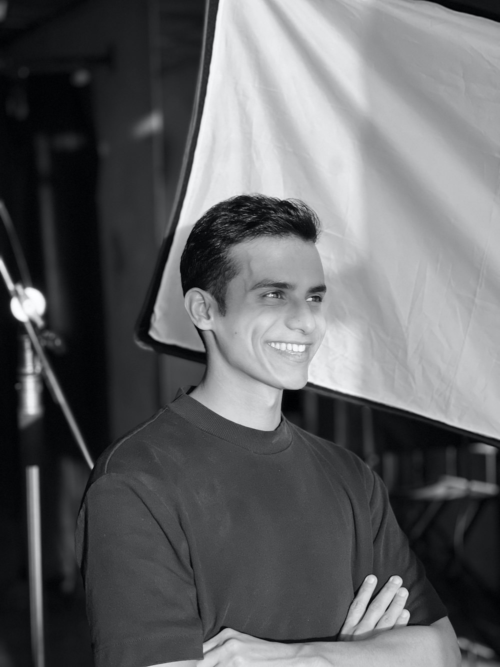 a man standing in front of a camera with his arms crossed