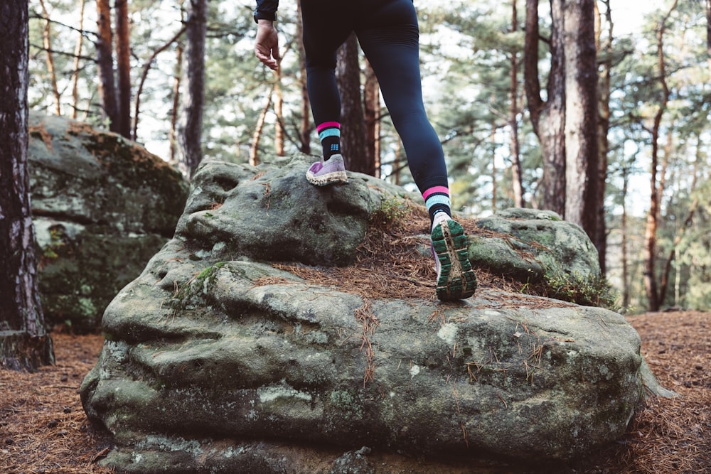a person walking on a rock in the woods