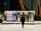 A person stands in front of illuminated outdoor boards displaying various posters with text and images in a snowy environment. The posters cover topics such as events and advertisements, and the scene is set against a background of a wall with mural art.