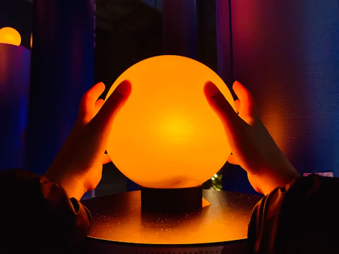 Close-up of hands gently holding a glowing model of a human immune system.