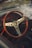 A woman admiring a stylish steering wheel in a showroom.