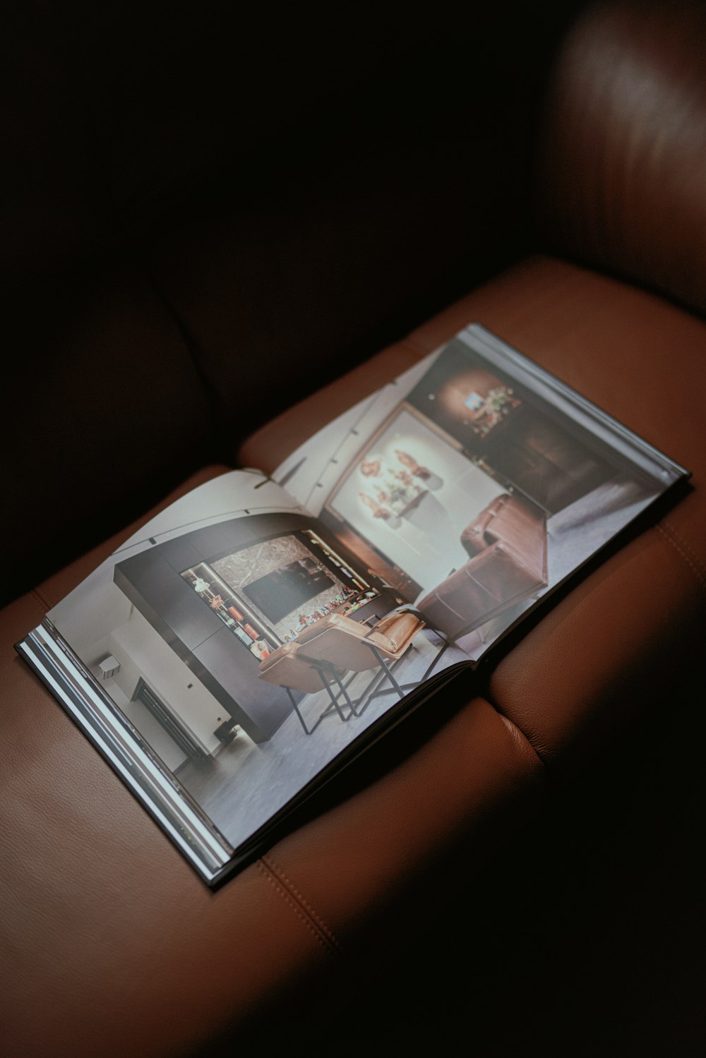 a magazine sitting on top of a brown leather couch
