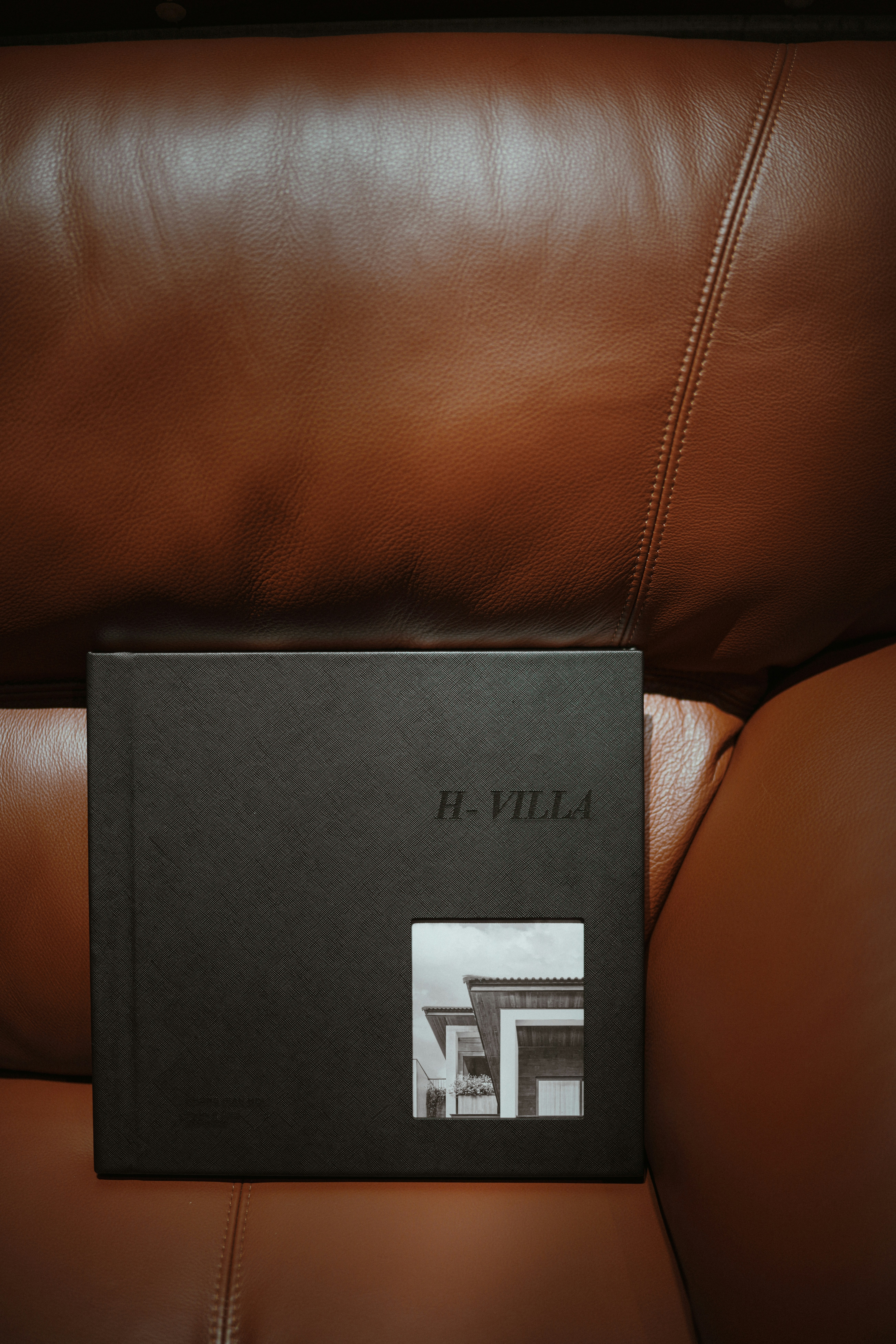 a book sitting on top of a brown leather couch