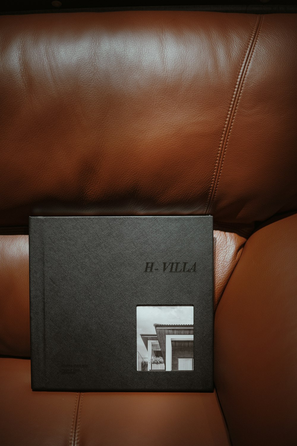 a book sitting on top of a brown leather couch