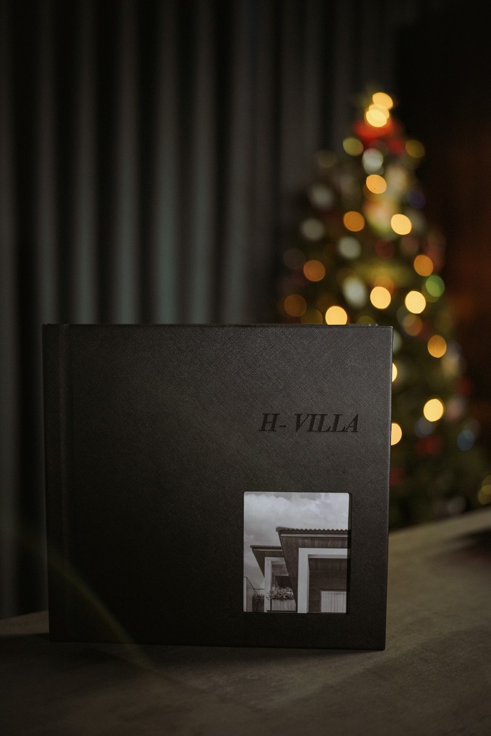 a black box with a picture of a building in front of a christmas tree