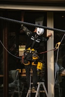 A team member using professional tools to reach high windows on a commercial building.