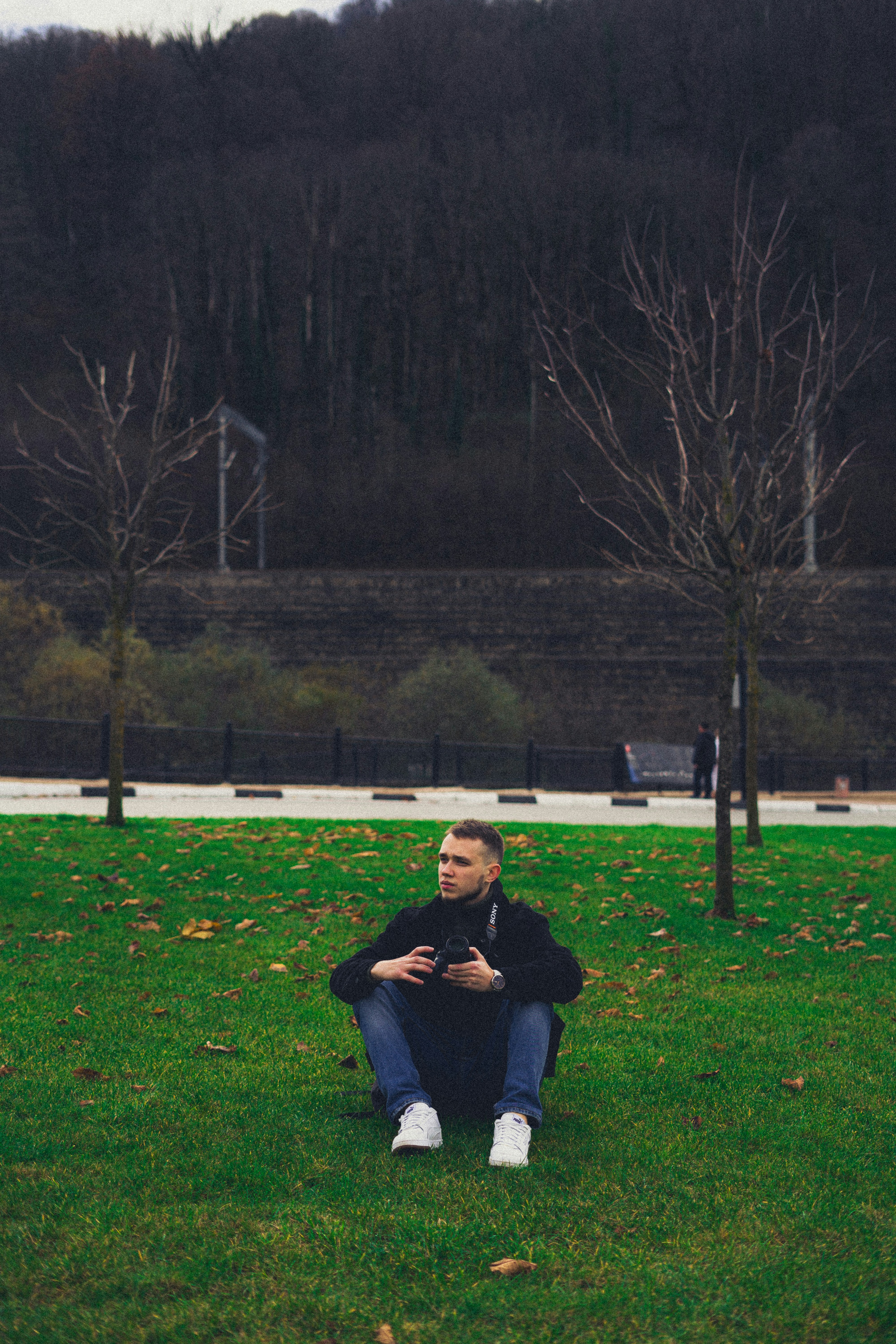 a man sitting on the ground in a park