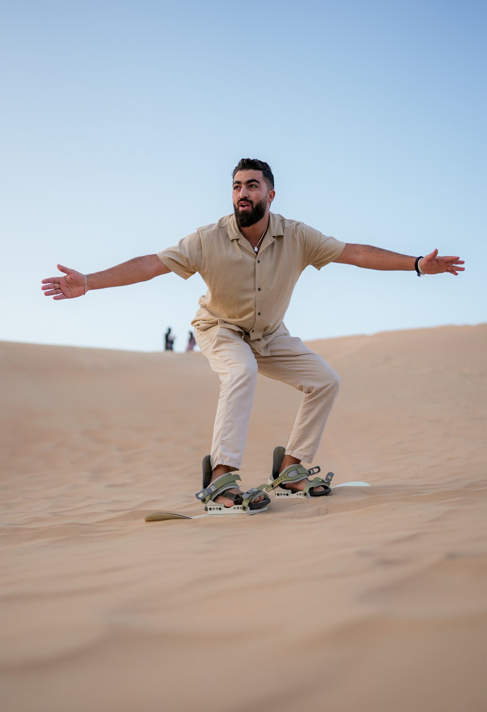 a man riding a skateboard on top of a sandy hill