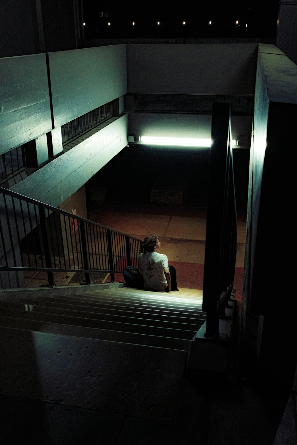 a person sitting on the steps of a building at night