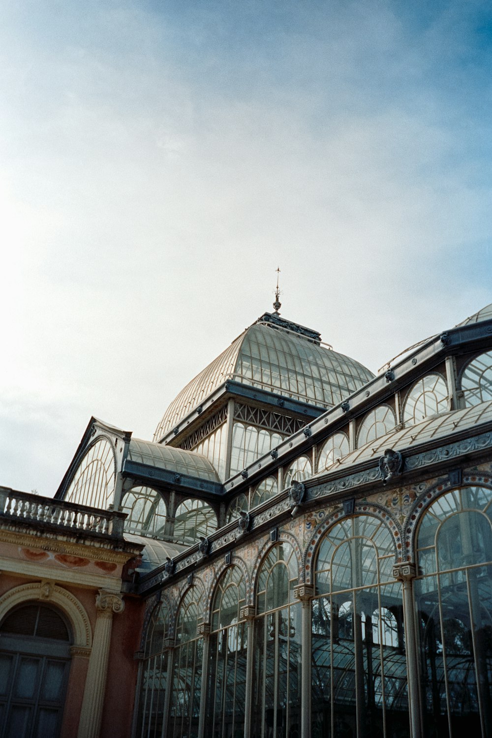 a large glass building with a clock on the top of it