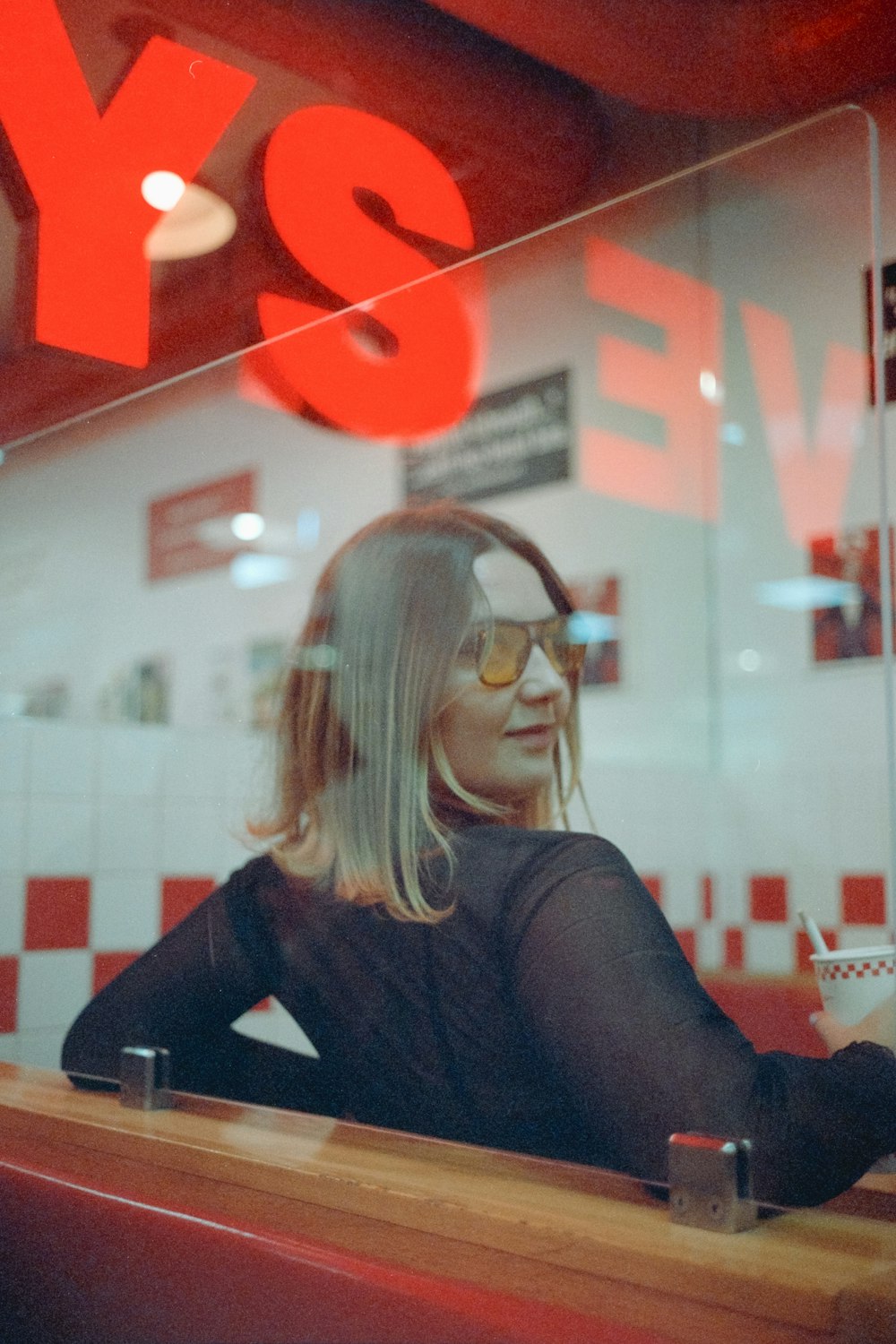 uma mulher sentada em uma mesa em frente a uma janela