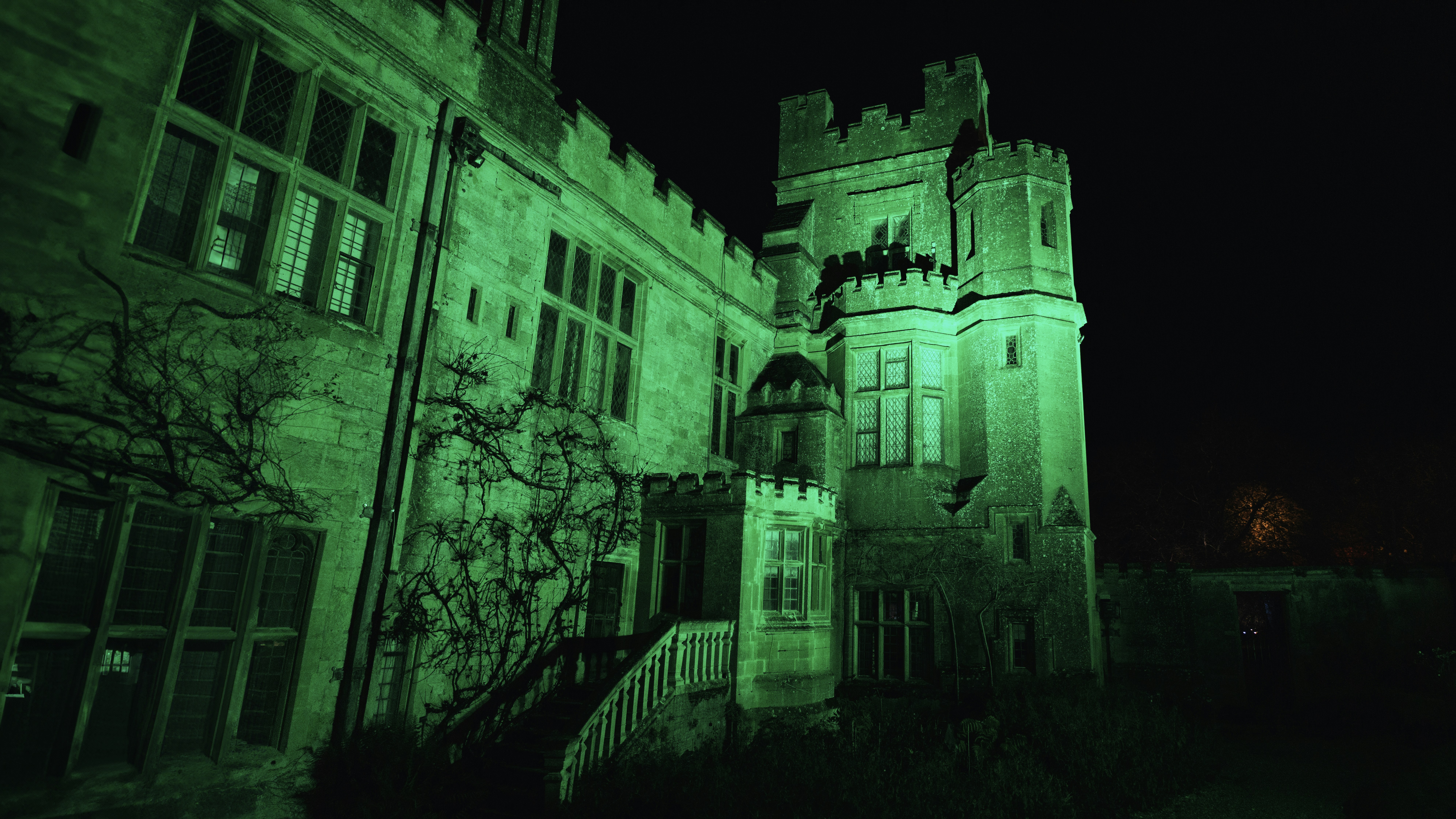 Un gran edificio con una torre de reloj iluminada por la noche