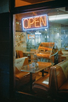 Interior of a burger restaurant decorated with 80s and 90s rock memorabilia and neon lights.