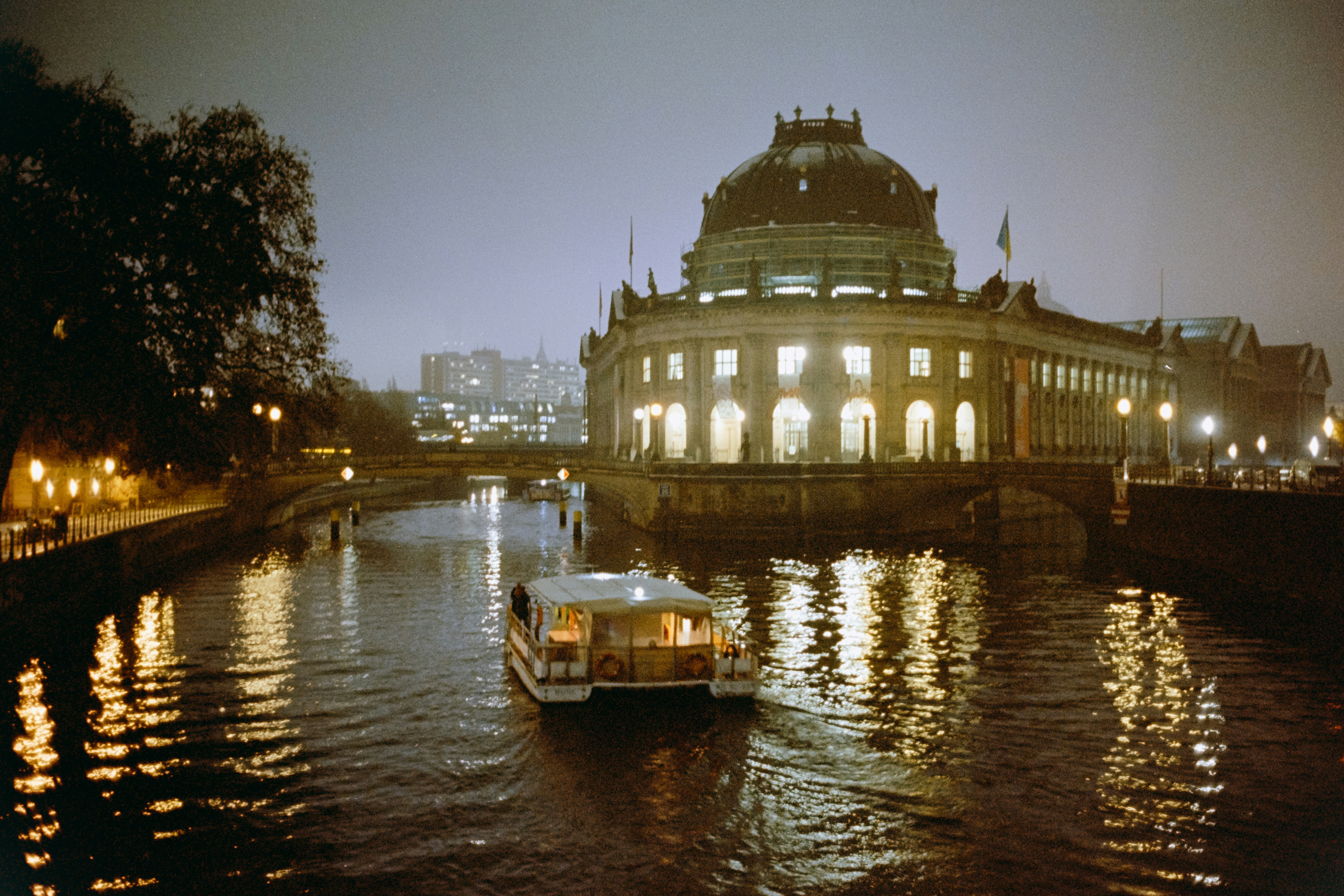 a boat traveling down a river next to a large building