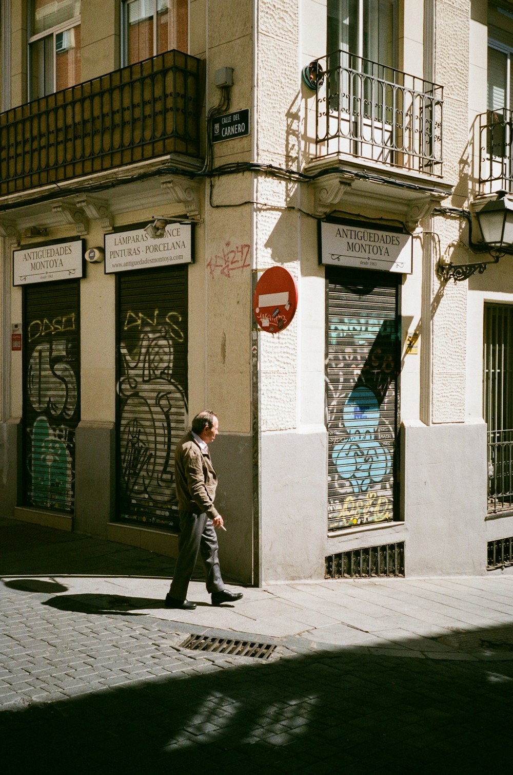 a man walking down a street next to a tall building