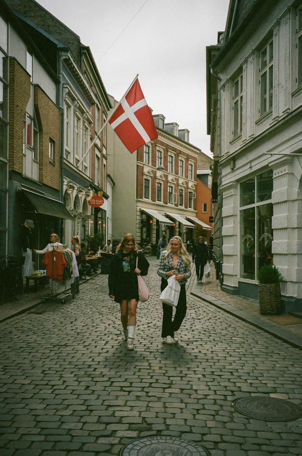 two women walking down a cobblestone street