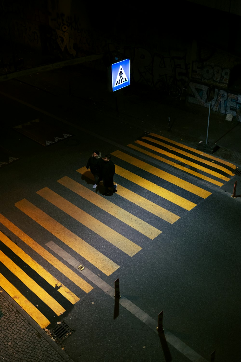 a person sitting on the ground in the middle of a crosswalk