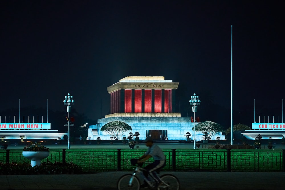 uma pessoa andando de bicicleta em frente a um prédio