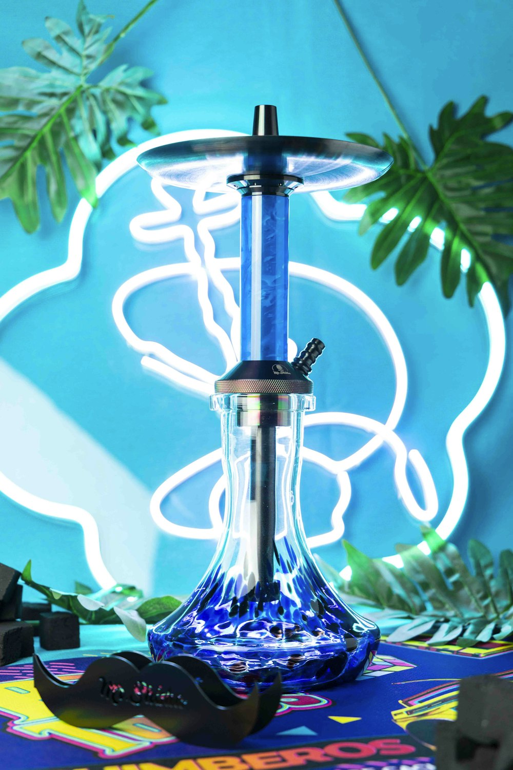 a blue glass hookah sitting on top of a table
