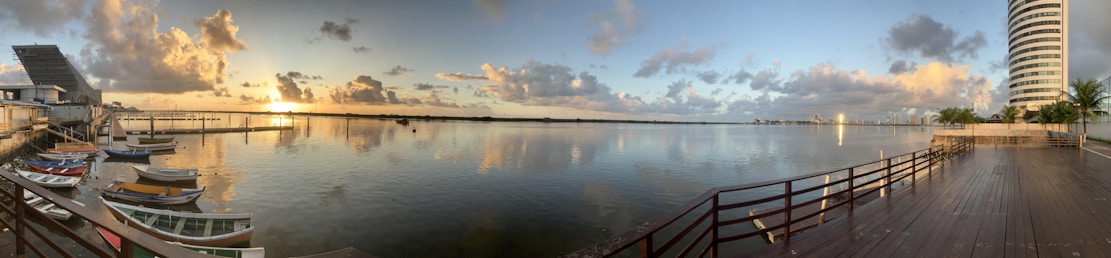 Sunset view of the waterfront resort site with calm Gulf waters and a wooden boardwalk.