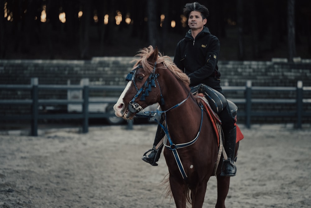 a woman riding on the back of a brown horse